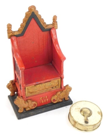 A cast novelty Elizabeth II Coronation throne money box, the red and gold ground marked ER 1953, 22cm high, and a vintage tape measure. (2)