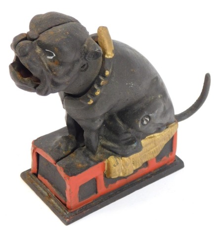 A novelty cast money box, formed as a bulldog on red book perch, 17cm high.