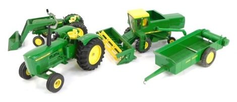 John Deere diecast agricultural vehicles, comprising spreader, toy combine, utility tractor with end loader and the Ertl Toys 5020 tractor, each boxed. (4)