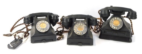 A collection of three vintage black Bakelite telephones, one on a stand. (AF)