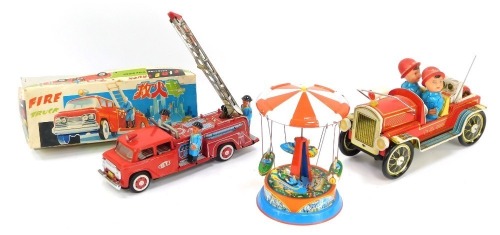 A group of tinplate toys, comprising a tinplate spinning ferris wheel, 20cm high, a fire truck, and a Japanese fire truck, boxed. (3)