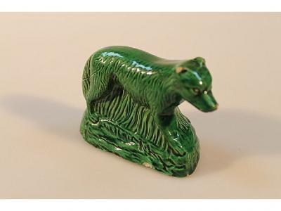 An 18thC pottery green glazed figure of a dog in a semi crouching stance