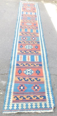 A Kashgai kilim rug, red, blue and green weave and knotted design, 387cm x 80cm.