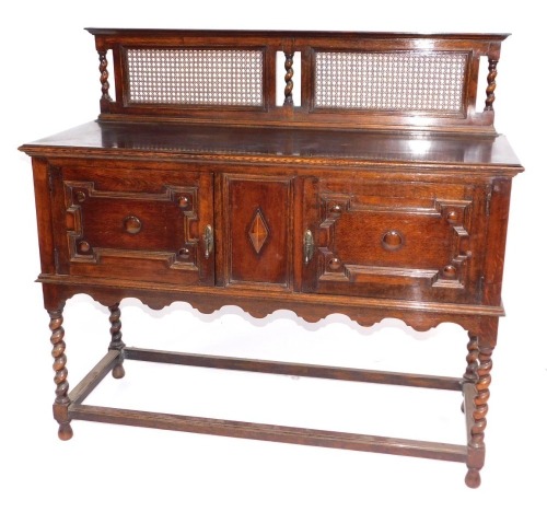 A 1920's barley twist oak sideboard, with caned back, 137cm wide.