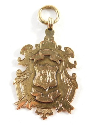 A Victorian 9ct gold fob, with scroll outline, centred by a shield, marked verso C & D J L 1898 Winners Pudsey Cemetery Rd C. C., 5cm high, 8g.