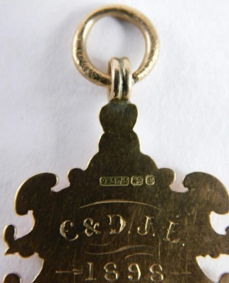 A Victorian 9ct gold fob, with scroll outline, centred by a shield, marked verso C & D J L 1898 Winners Pudsey Cemetery Rd C. C., 5cm high, 8g. - 3