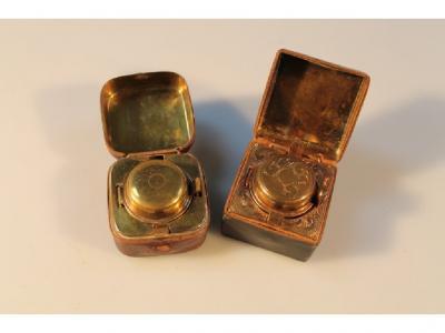 Two small travelling ink wells with a leather over metal case