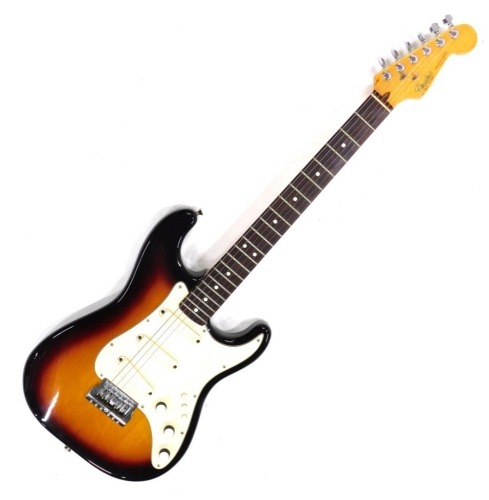 A Fender Stratocaster electric guitar, six string, in cream and vinyl finish, no.323681, 99cm long., cased.