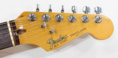 A Fender Stratocaster electric guitar, six string, in cream and vinyl finish, no.323681, 99cm long., cased. - 2