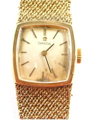 An Omega 9ct gold cased wristwatch, with a square curved set dial, on bark effect bracelet, the dial 2cm diameter, 19cm long, 34g all in, boxed with paperwork.