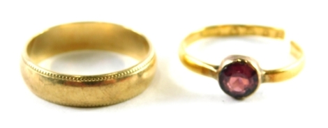 Two rings, comprising a 9ct gold wedding band with outer reeded design, ring size P and a cut band set with garnet, rubbed hallmarks, possibly 22ct, 5.2g all in. (2)