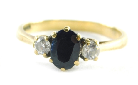 A 9ct gold dress ring, set with two CZ and a central dark blue imitation sapphire, ring size O, 2.2g all in.