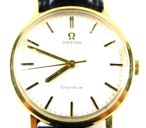 An Omega Geneva gentleman's wristwatch, with a silver coloured dial, in yellow metal case, unmarked, believed to be 9ct gold, 3cm diameter, on a black leather strap, boxed, 33.4g all in.