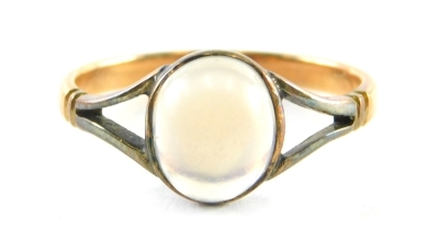 A moonstone dress ring, the oval moonstone in a rubover white gold setting with V splayed shoulders and yellow metal band, with rubbed marks, ring size P, 2.2g all in.