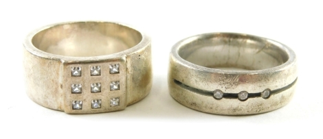 A sterling silver band, set with small white stones, size V, and another, in Buckingham Palace box. (2)