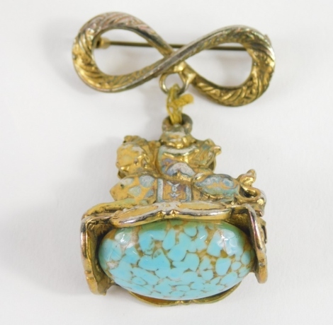 An unusual sphinx headed fob pendant, with figure of eight top and plain pin back, 5cm high.