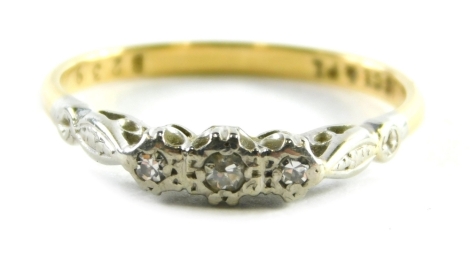 A 18ct gold and platinum diamond three stone ring, set with three tiny diamonds in illusion setting on a yellow metal band, ring size O, 2.4g all in.