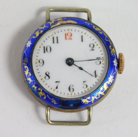 An early 20thC silver and enamel watch head, raised with gilt coloured flowers and marked silver, with fancy 2.5cm diameter Arabic dial and blue enamel back. (AF)