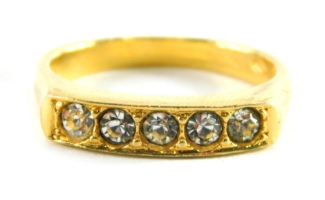 A dress ring, set with five paste stones on a plated band.