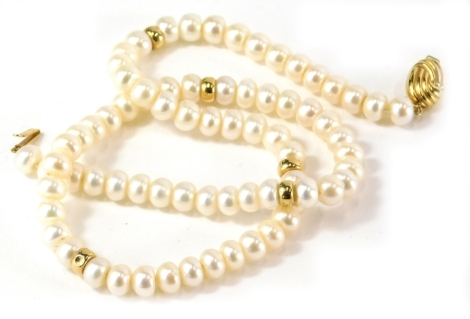 A cultured pearl single strand necklace, with rounded beads, and gold coloured brakes, with oval swirl design clip in clasp yellow metal stamped 925, 48cm long overall, 31.9g all in.