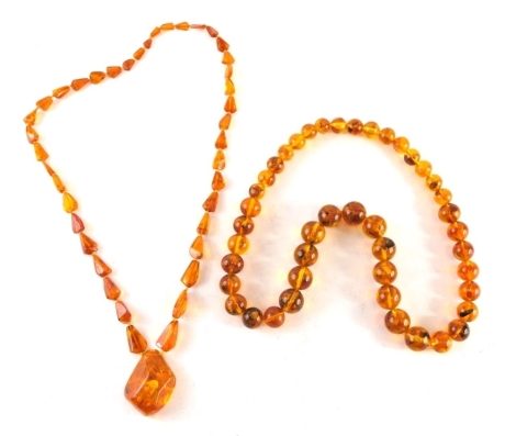 Two imitation amber beaded necklaces, comprising a graduated beaded necklace on string strand, 60cm long, and a chain and pendant, 76cm long.