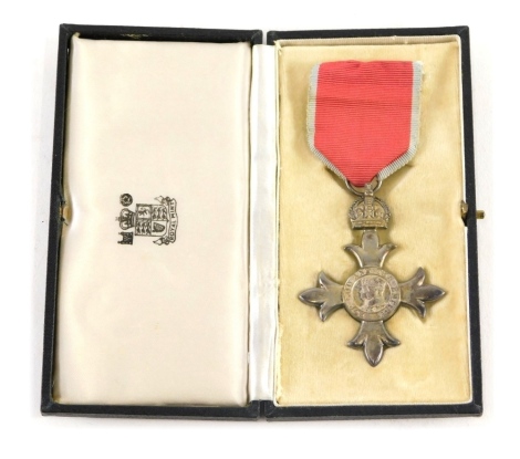 A cased MBE medal with ribbon, 9cm high.