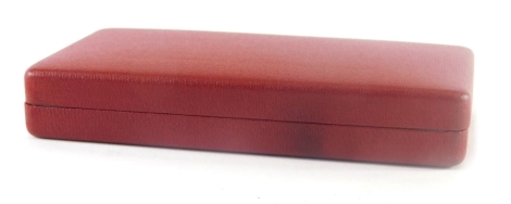 A red Moroccan finish sovereign case, 16cm wide.