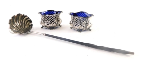 A pair of Edward VII silver salts, each of boat form, partially pierced, repousse decorated with scrolls and flowers, with blue glass liners, Birmingham 1905, 4cm high, and a toddy ladle with turned whale bone handle and shaped shell bowl. (3)