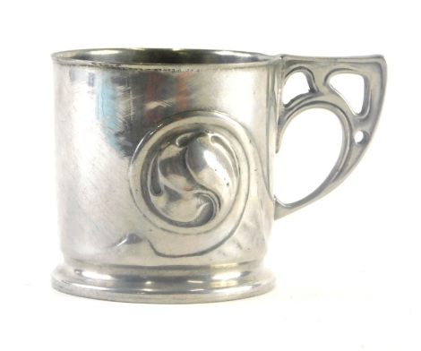 An early 20thC Liberty Tudric pewter cup, with Solkets mark, pierced angular handle and repousse decorated body decorated with scrolls, numbered 0358, 8cm high.