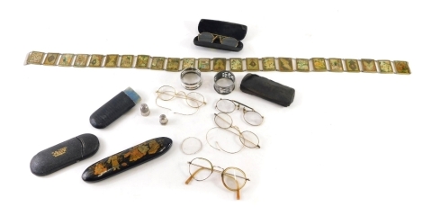 Various silver and related effects, an early 20thC Japanned spectacles case, decorated with figures with gilt highlights on black ground, 16cm long, an Eastern belt decorated with panels of flowers, pince-nez, other spectacles, silver thimble, two napkin 