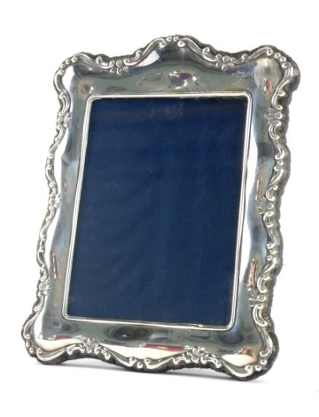 An Elizabeth II silver photograph frame, with serpentine design with blue velvet easel back, Sheffield 1992, 14cm high, 11cm wide.