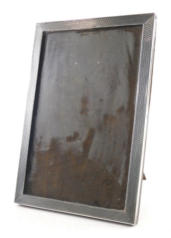 A George V silver photograph frame, by Sanders and Mackenzie, of rectangular form, partially engine turned, with oak easel back, Birmingham 1927, 20cm x 13cm.