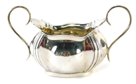 A George V silver Art Nouveau style two handled sugar bowl, with flared rim, bomb body and oval foot, flanked by S scroll handles, Sheffield 1919, 10cm high, 3.4oz.