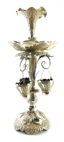 An early 20thC epergne, with flared trumpet centre, shaped dish holder, and acanthus leaf stem, on a highly decorated scroll base, with further repousse decoration, and three baskets, white metal unmarked possible Indian, 40cm high.