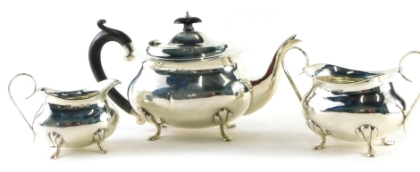 A George V silver three piece tea service, by Joseph Gloster, comprising teapot of cape form, with ebonised thumb mould handle, 14cm high, two handled sugar bowl and milk jug, Birmingham 1919, 23.5oz all in. (3)