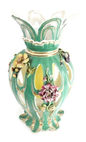 A Continental porcelain floral centrepiece, the removable crown top partially pierced raised above a shaped body raised with flowers, with white dot and gilt highlights on green ground, unmarked, 49cm high.