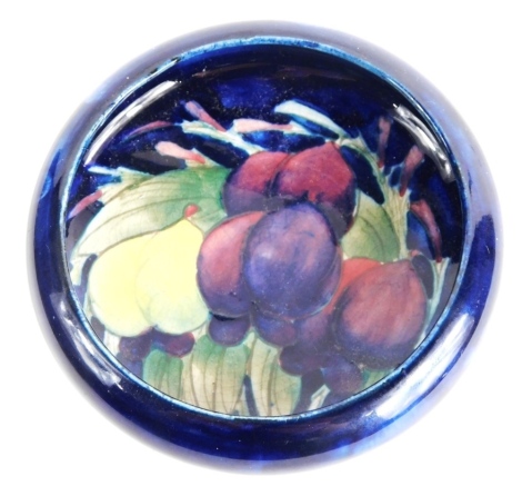 A 20thC Moorcroft wisteria pattern bowl, of circular form, on blue ground, 10cm diameter.