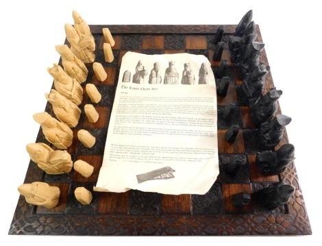 A Lewis Androil chess set, with 10cm high white king and heavily carved board.