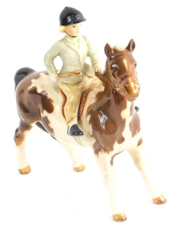 A Beswick figure Girl on a Pony, green jacket, marked beneath, 15cm high.