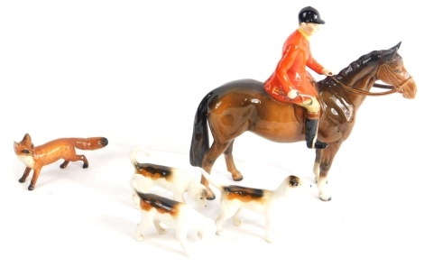 A Beswick red jacketed huntsman, 23cm high, three hounds and a fox.