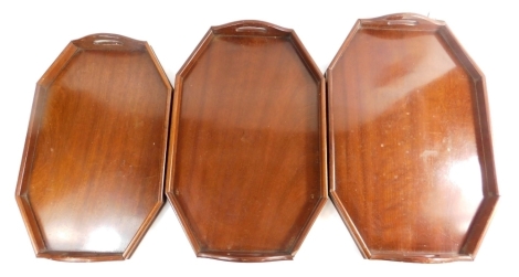 A graduated set of three octagonal tea trays, each with pierced handles.