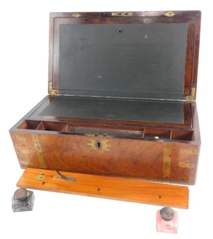 A 19thC brass bound writing slope, of rectangular form, with fitted interior, hinged writing sections, space for ink bottles and pens, with an elaborate escutcheon to the exterior, 45cm wide, 16cm high, 23cm deep.