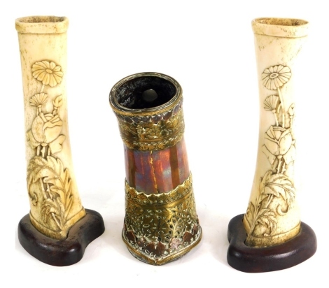 A pair of bone shin vases, each heavily carved with flowers and a copper and brass horse leg guard, now hammered probably part of a horseshoe, 16cm high. (3)