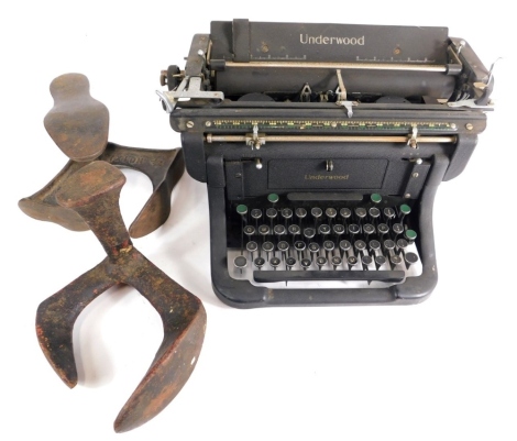 A 20thC Underwood typewriter, in black with chrome insert and articulated keys, 35cm wide, and two cobbler's anvils. (3)