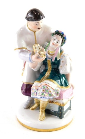 A Russian figure group, The Golden Slippers, signed Lomonosov, c. 1950s in rare colourway, polychrome decorated with gilt highlights and marked beneath, 13cm high.