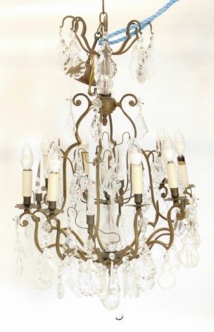 A 20thC metal and cut glass eight branch chandelier, with a double central baluster column, with two sections of S scroll dish holders, each holding a candle with cut glass octagonal and floral sections, with further cut glass floral sections and part ele