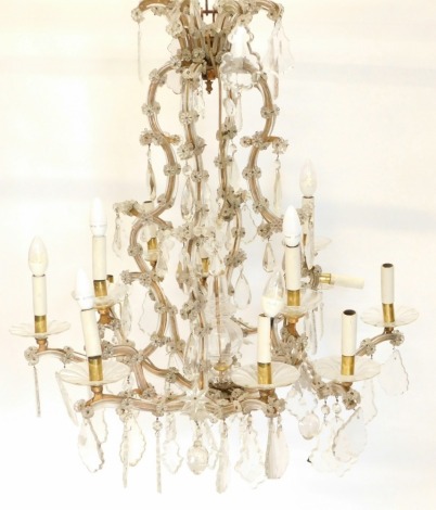 A 20thC twelve branch chandelier, the central baluster section set with various shaped arms holding candles and circular dish holders, each enriched with floral cut glass pieces and tear drop sections, within a metal frame, partially wired, 97cm high.