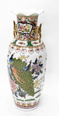 A modern Japanese floor standing vase, with flared rim, the shouldered body heavily decorated with peacocks and flowers, polychrome decorated predominately in yellow, blue, green and red, 97cm high.