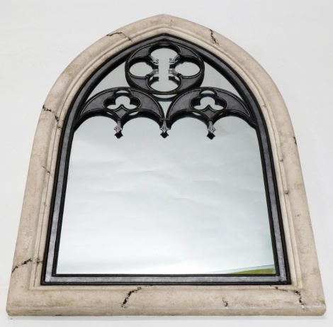 A mitre shaped mirror, with stone surround and pierced sections to the plain glass, 143cm high, 79cm wide, 8cm deep.