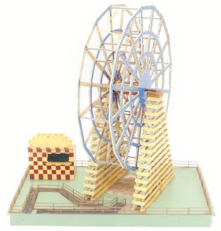 A scratch built wooden model of a fairground big wheel, on rectangular base with metal fittings, partially painted, 75cm wide.